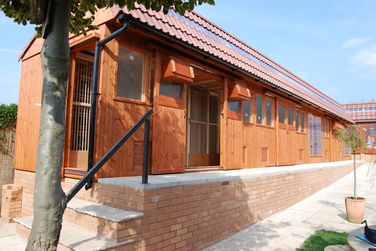 L-shaped pigeon loft with a tiled roof on a brick base