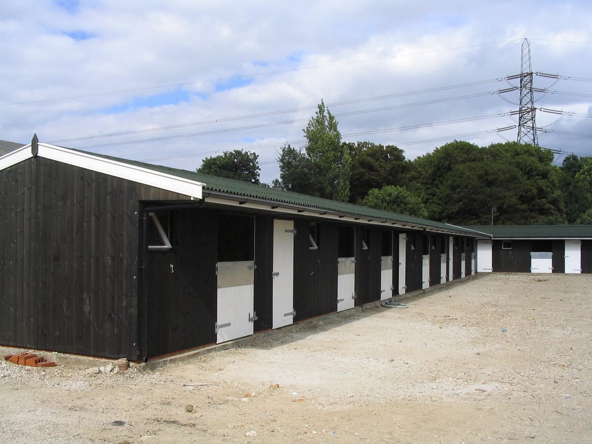 Large timber stable and tack room complex with a long run of loose boxes